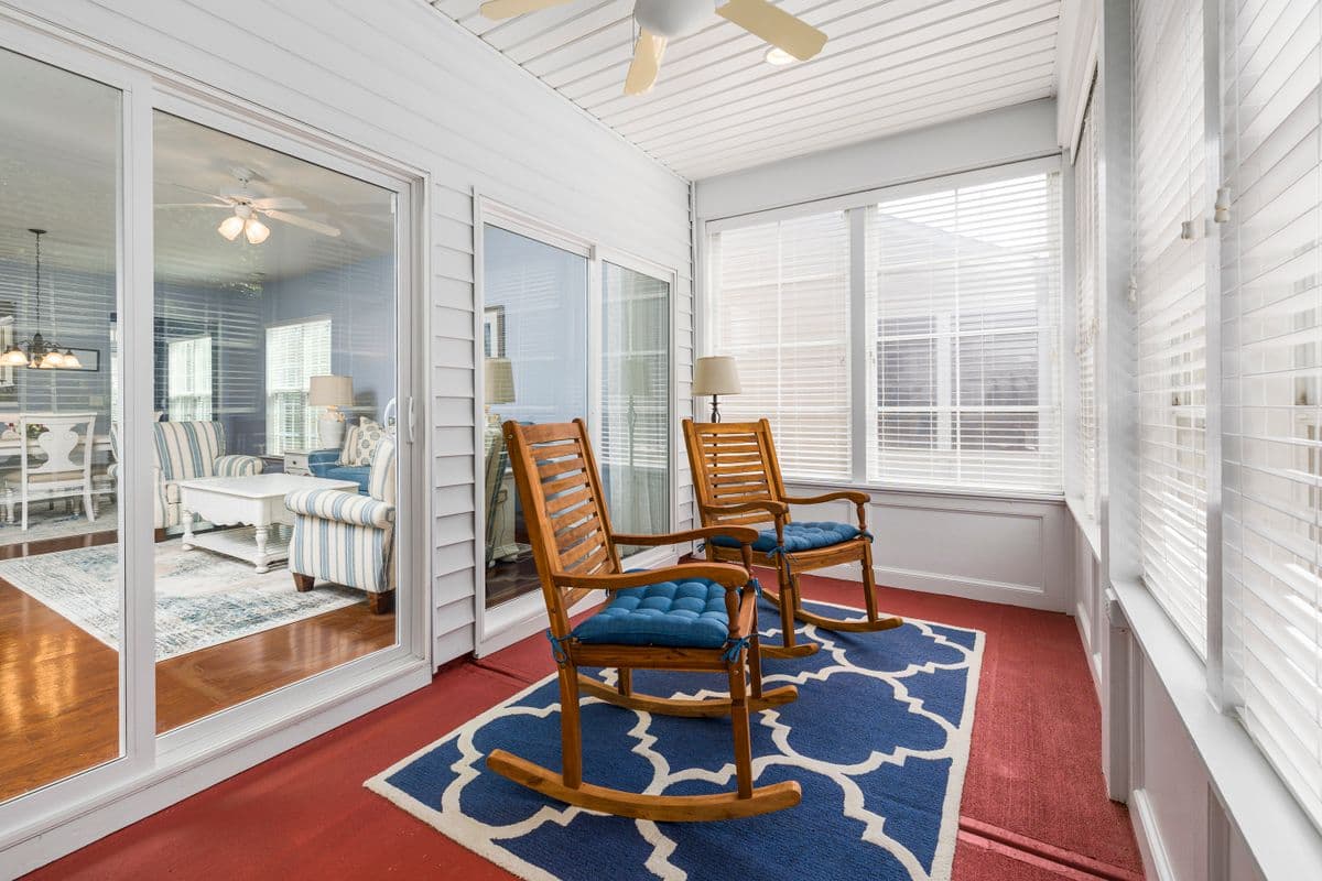 A bright sunroom with rocking chairs at a senior living community